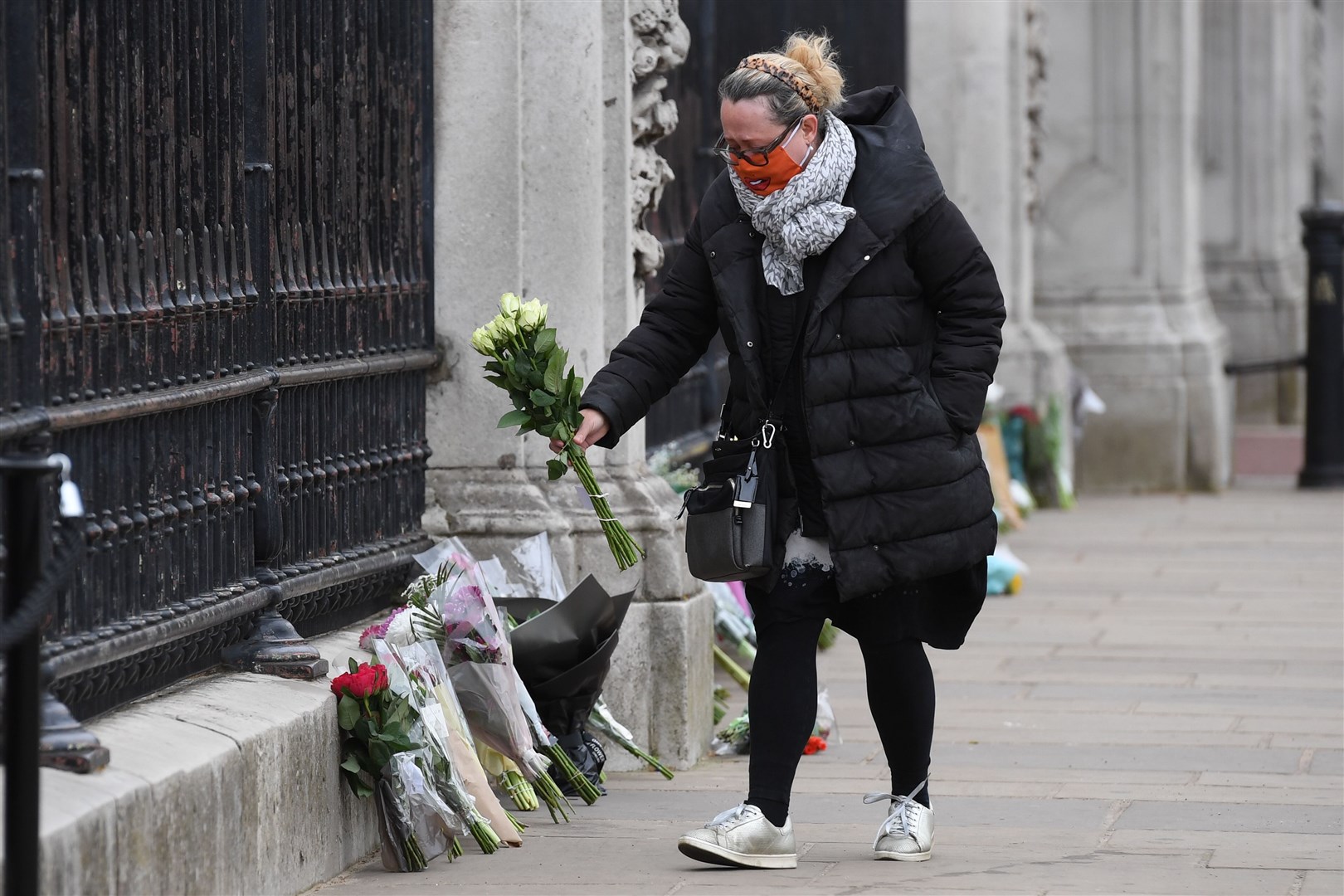A woman leaves flowers to honour the duke’s memory (Kirsty O’Connor/PA)