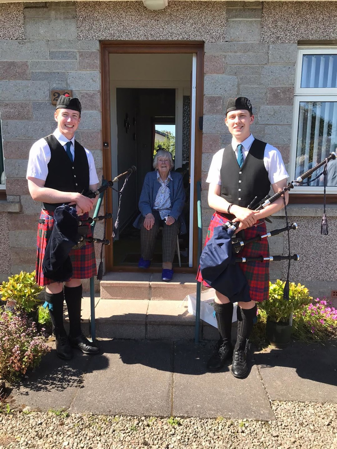 Barbara Rae flanked by pipers Ewan and Fraser Denoon.