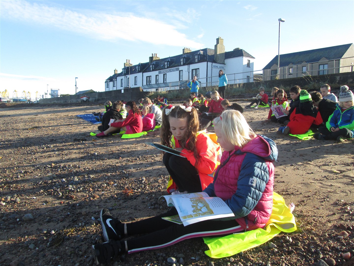 Children read on the beach at Cromarty.
