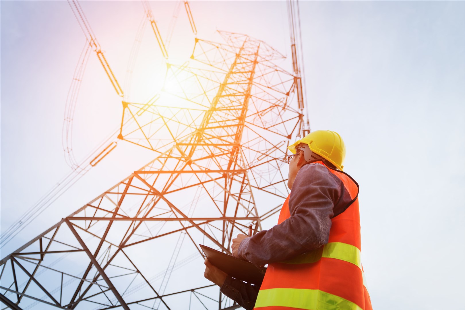 An engineer working on a high-voltage tower.