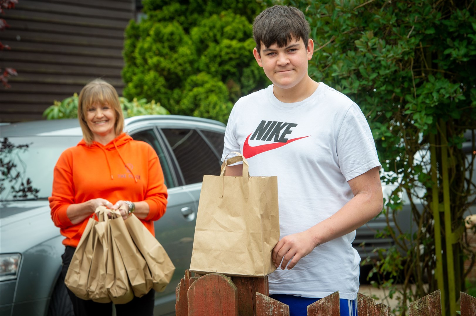 Goody bags being handed around to homes of Academy-aged children in Alness. Youth workerHelen Ross and one of the grateful recipients, Leo Mcallister. Picture: Callum Mackay