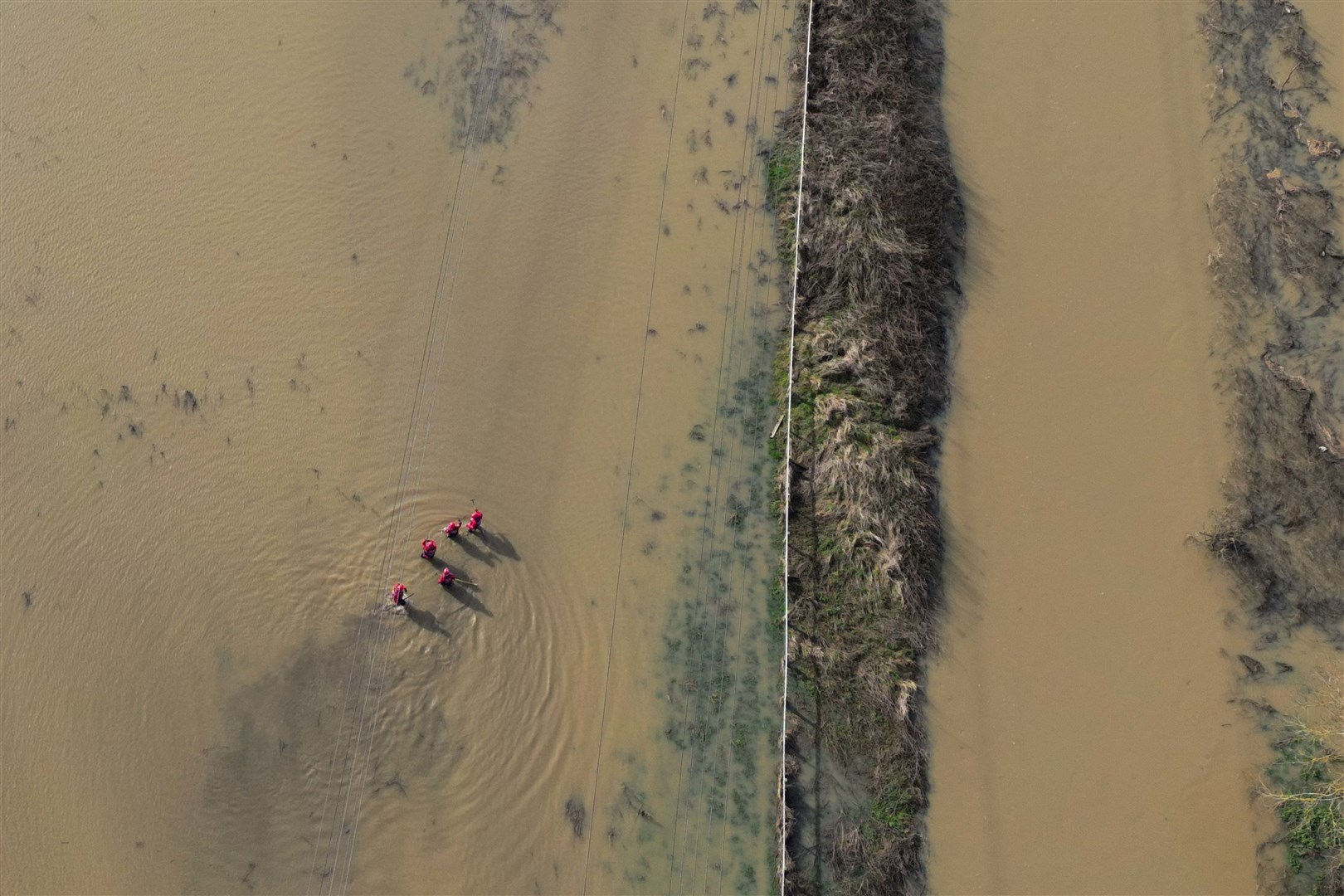 A search operation under way on flooded fields by the River Soar (Jacob King/PA)