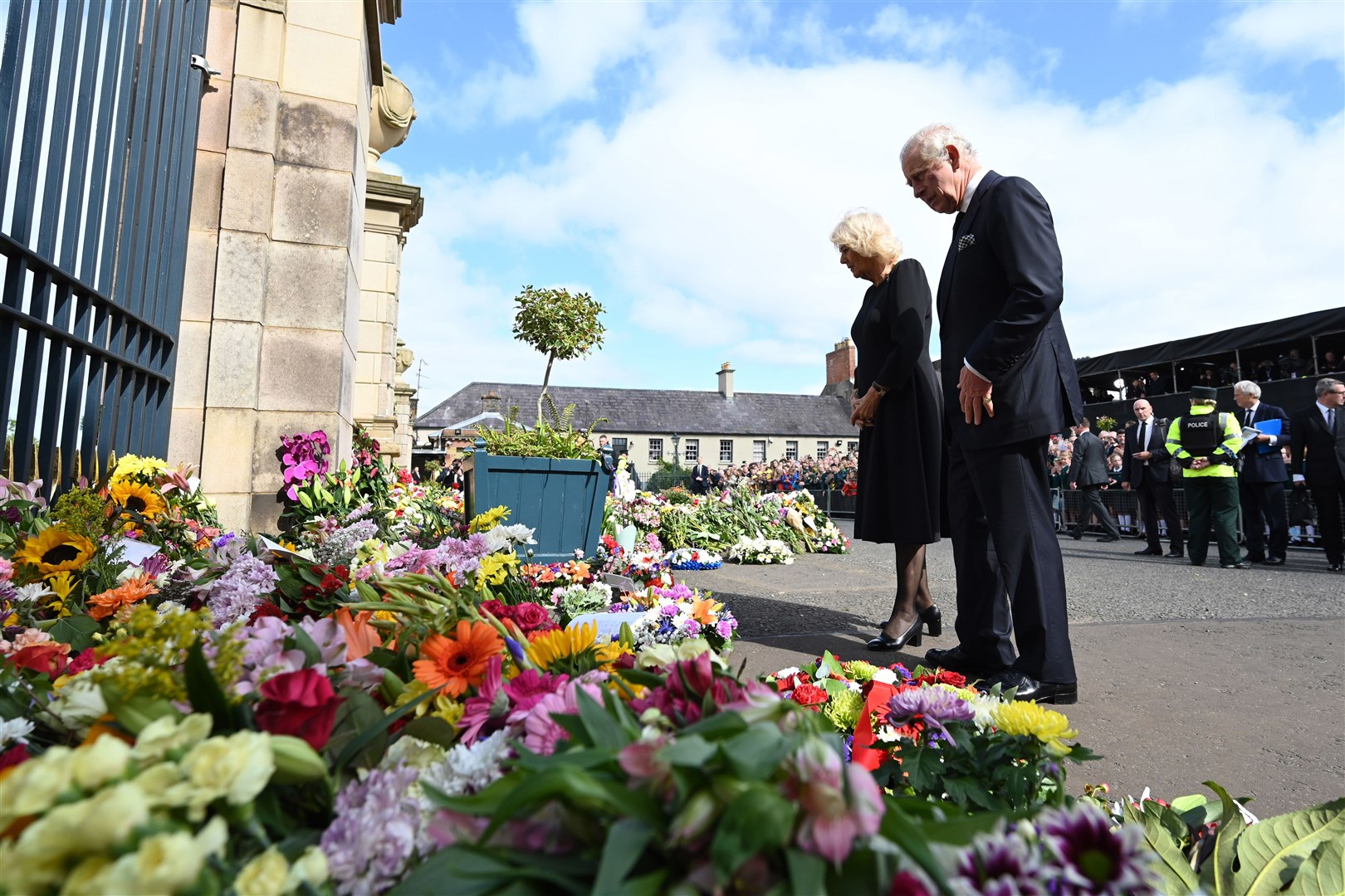 Charles and Camilla look at floral tributes at Hillsborough Castle (Michael Cooper/PA)