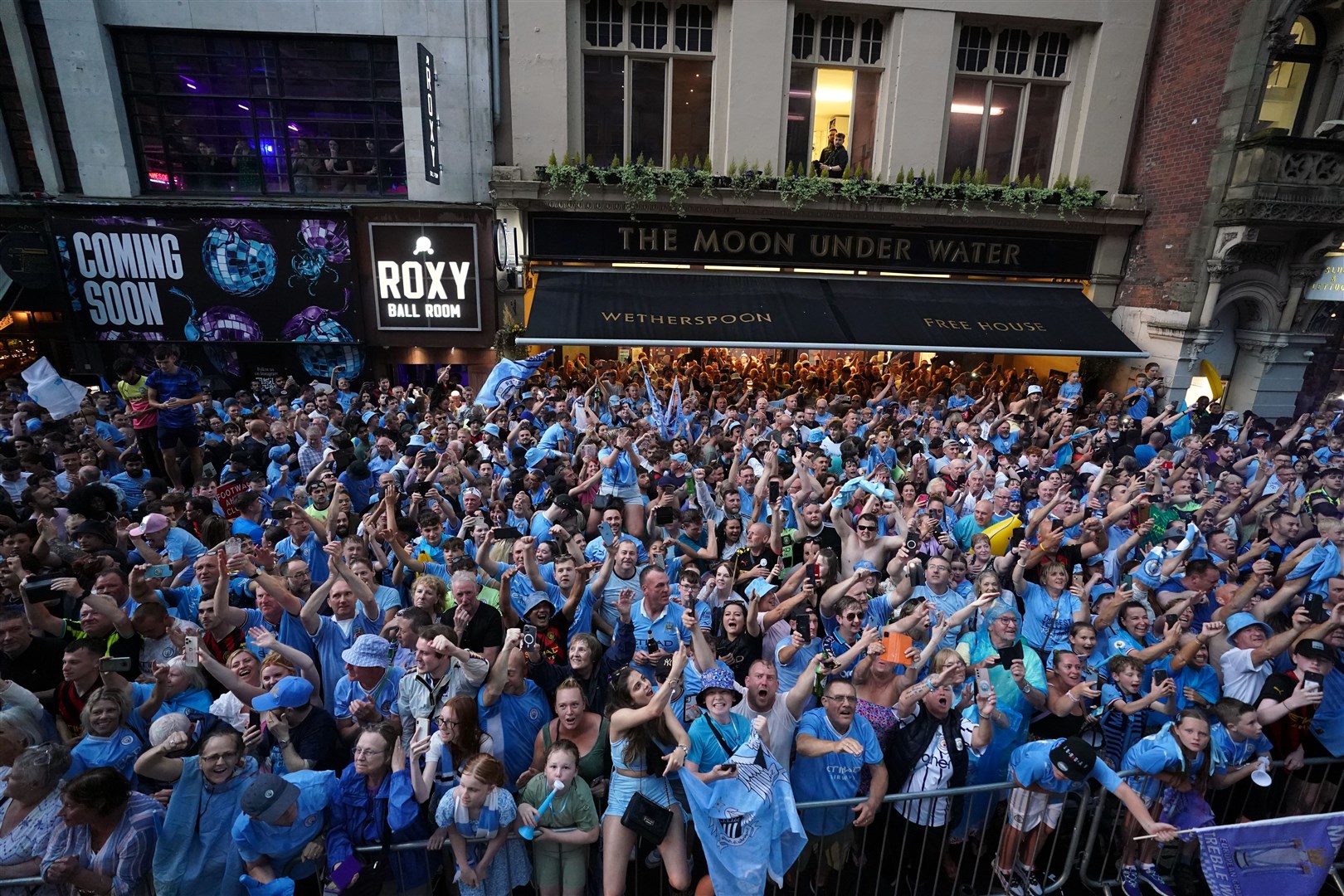 Thousands lined the street despite the torrential rain and threat of lightening to celebrate Manchester City’s success (Tim Goode/PA)