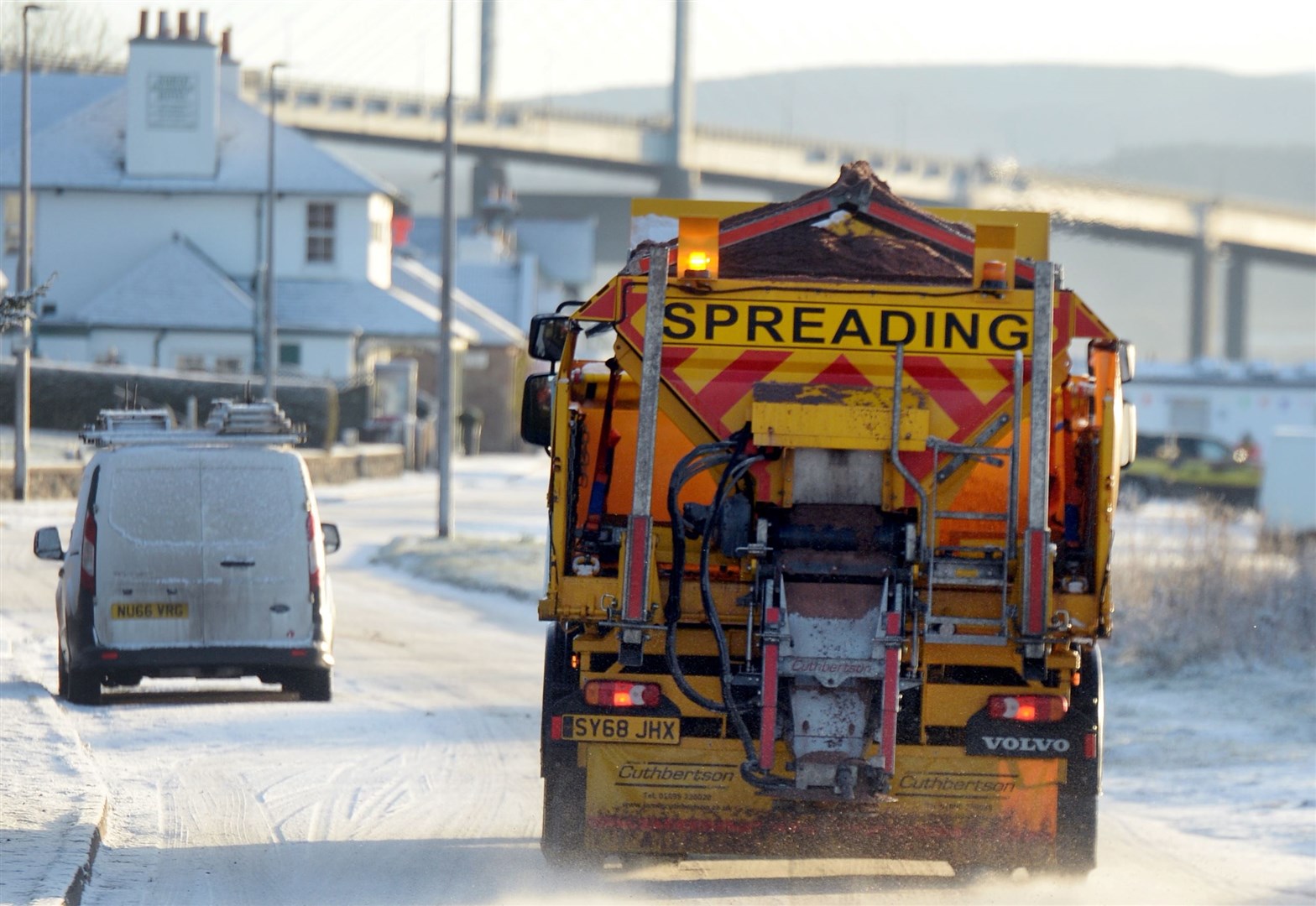 A wintry scene as a gritter works on the Black Isle.