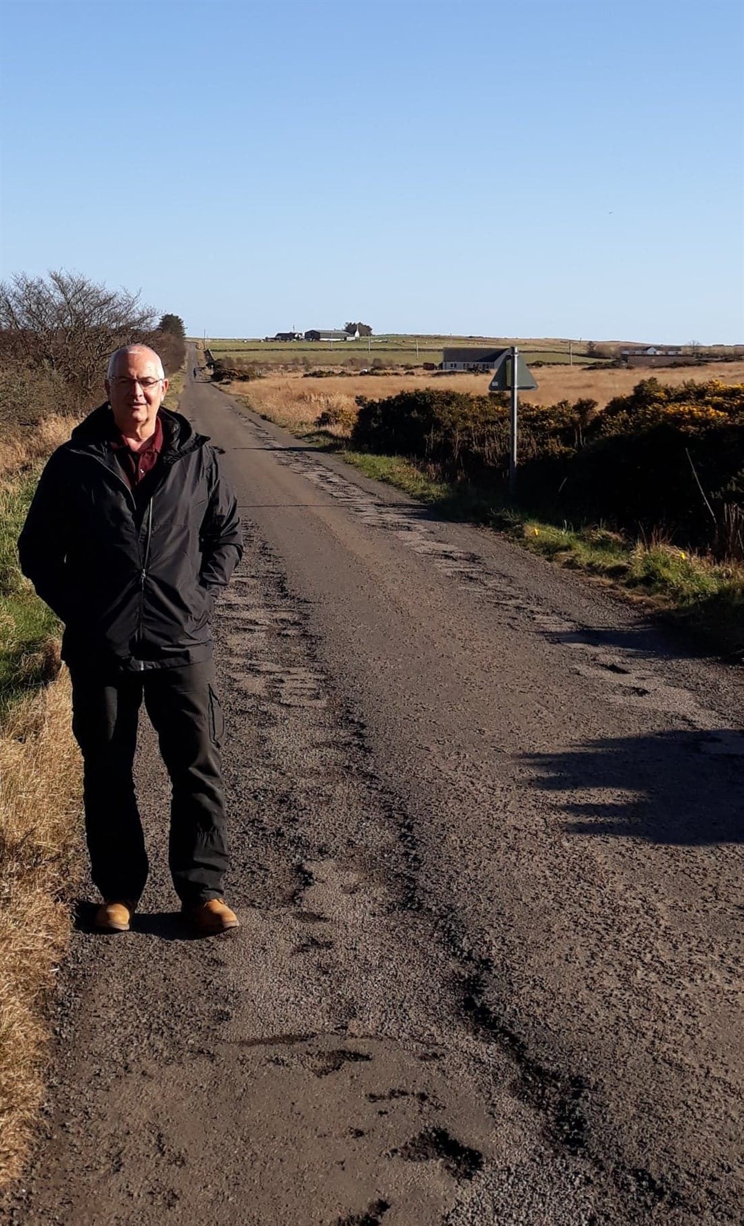 Cllr Raymond Bremner by a road that has been patch filled.