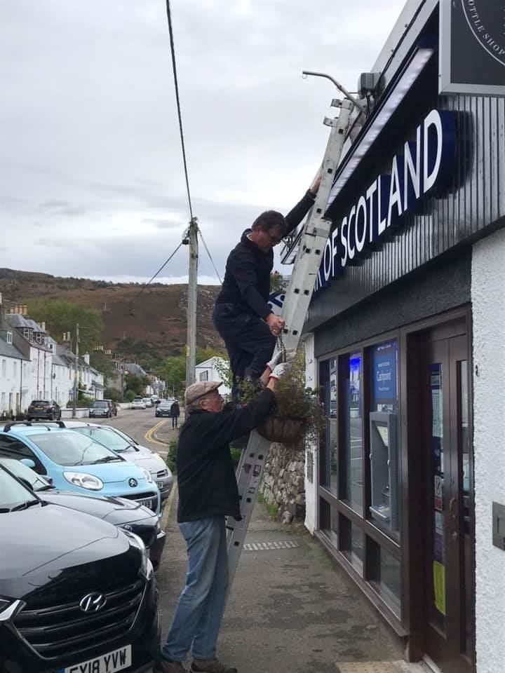 Angus Macpherson and Mike Turner take down the hanging baskets. Picture: Welcome Ullapool