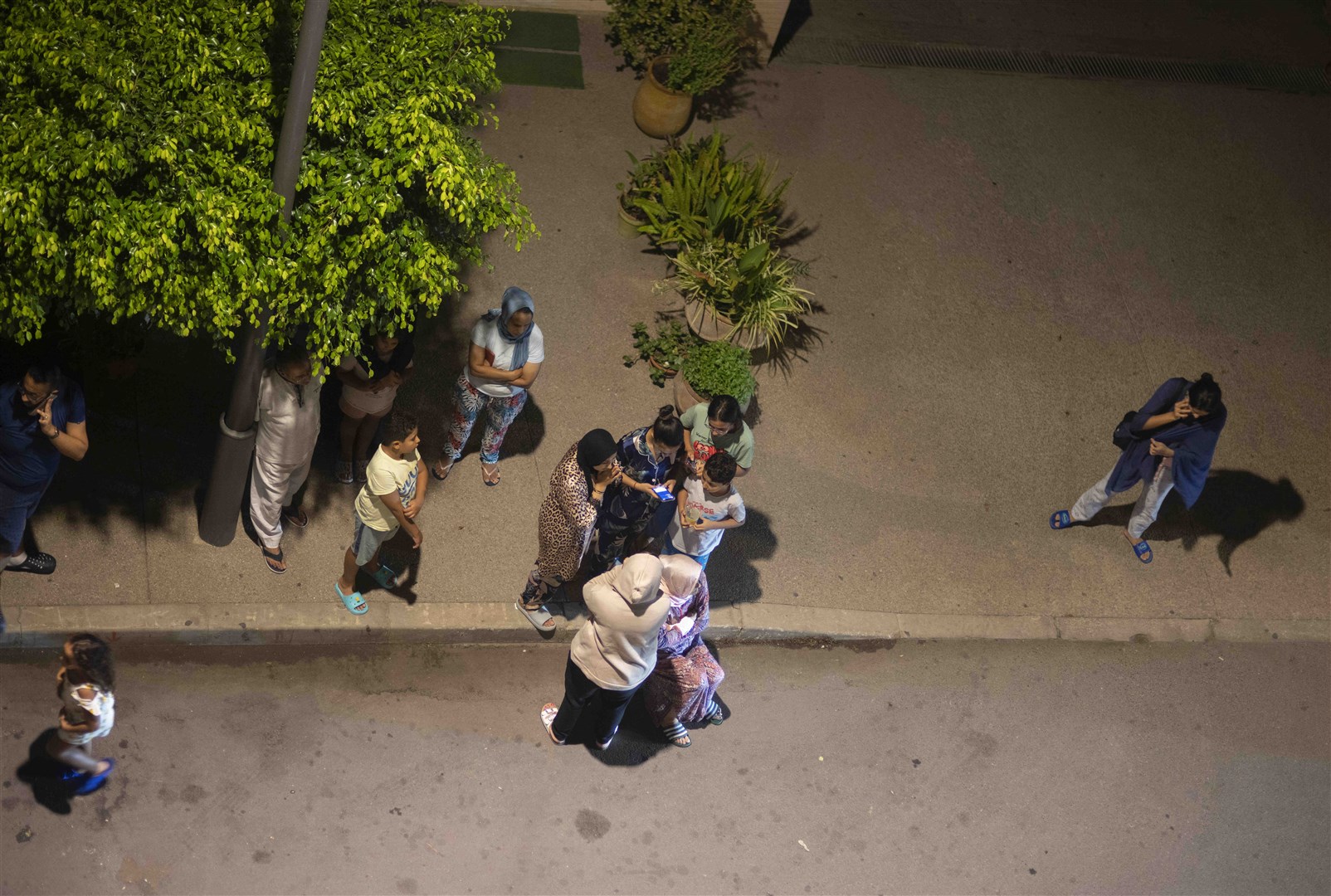 People take shelter outside and check for news on their mobile phones after the earthquake (Mosa’ab Elshamy/AP/PA)