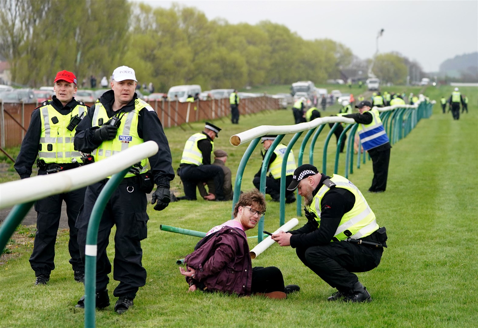 Animal Rising activists are apprehended by police officers as they attempted to invade the racecourse (Jane Barlow/PA)