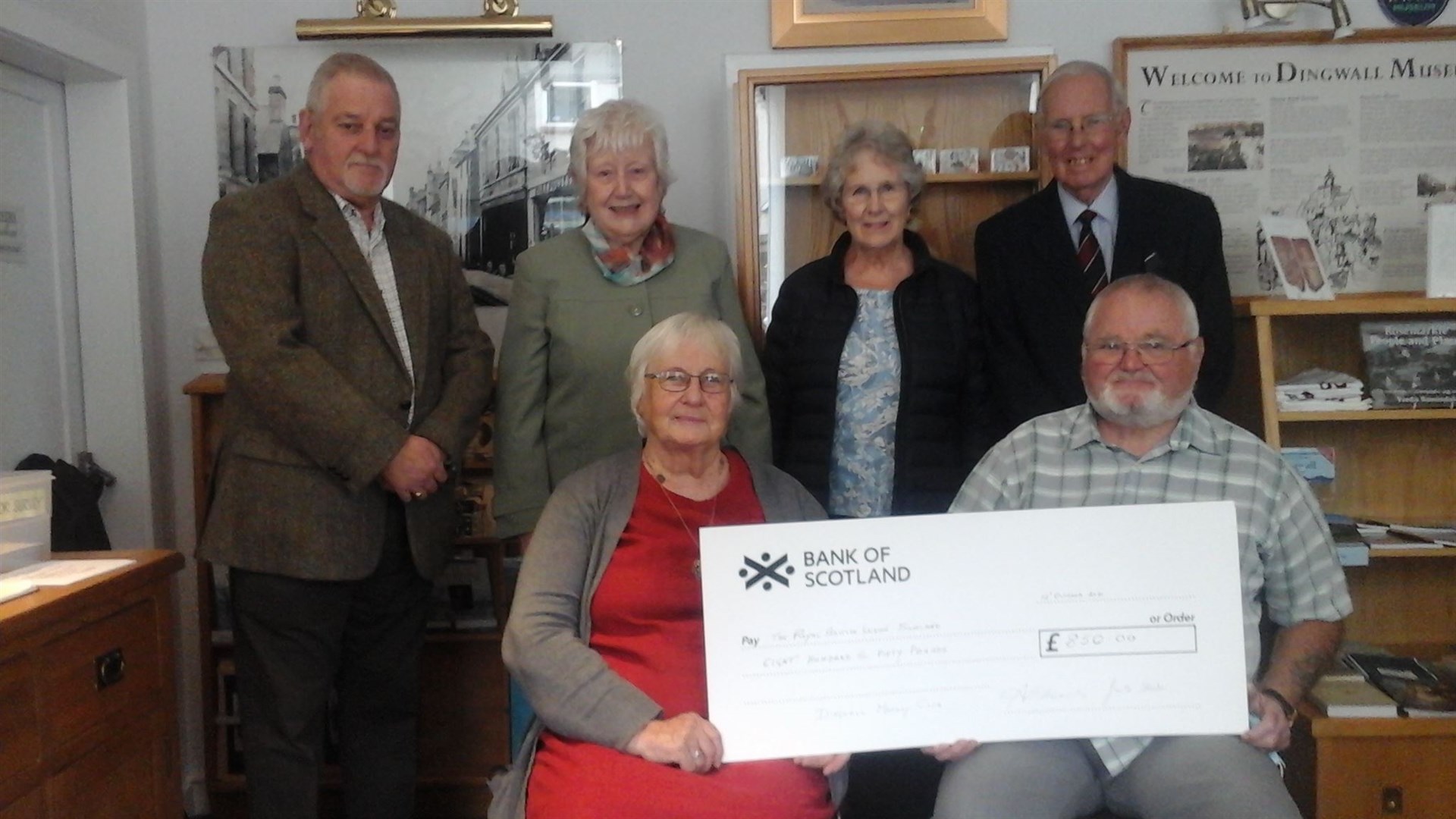 Monday Club cheque: Back Row Morris Colven, Anne Edwards, Daphne Fraser, Robert Moore Front Row Janette Steele, Fraser Campbell