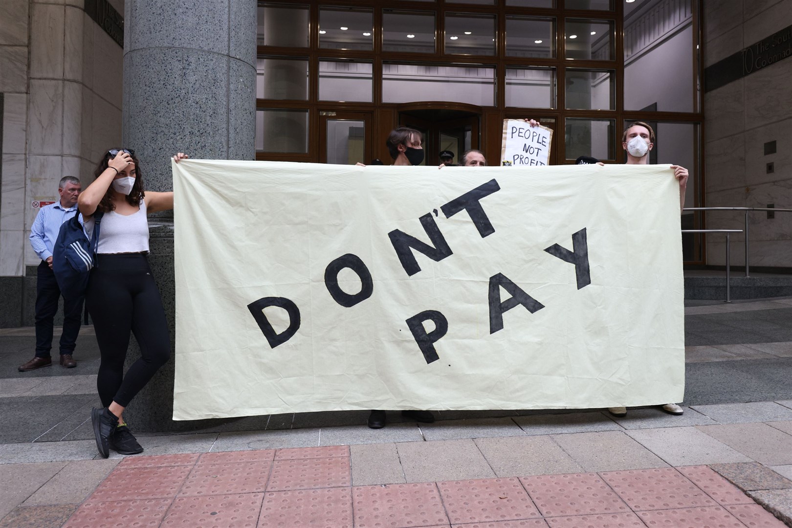A woman holds a banner during a protest outside the Ofgem HQ (James Manning/PA)
