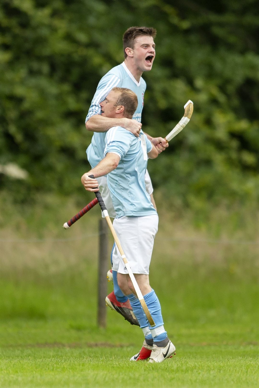 Caberfeidh’s Kevin Bartlett (front) makes it 5-3 against Lochaber to the delight of club captain Craig Morrison. Picture: Neil Paterson