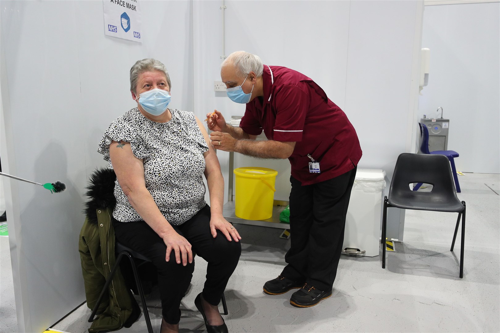 Robert Ward, 56, a retired nurse from Blackpool Victoria Hospital, injects Ms McLaren, the first patient to receive a dose of the Oxford/AstraZeneca coronavirus vaccine during a clinic at the Winter Gardens (Peter Byrne/PA)