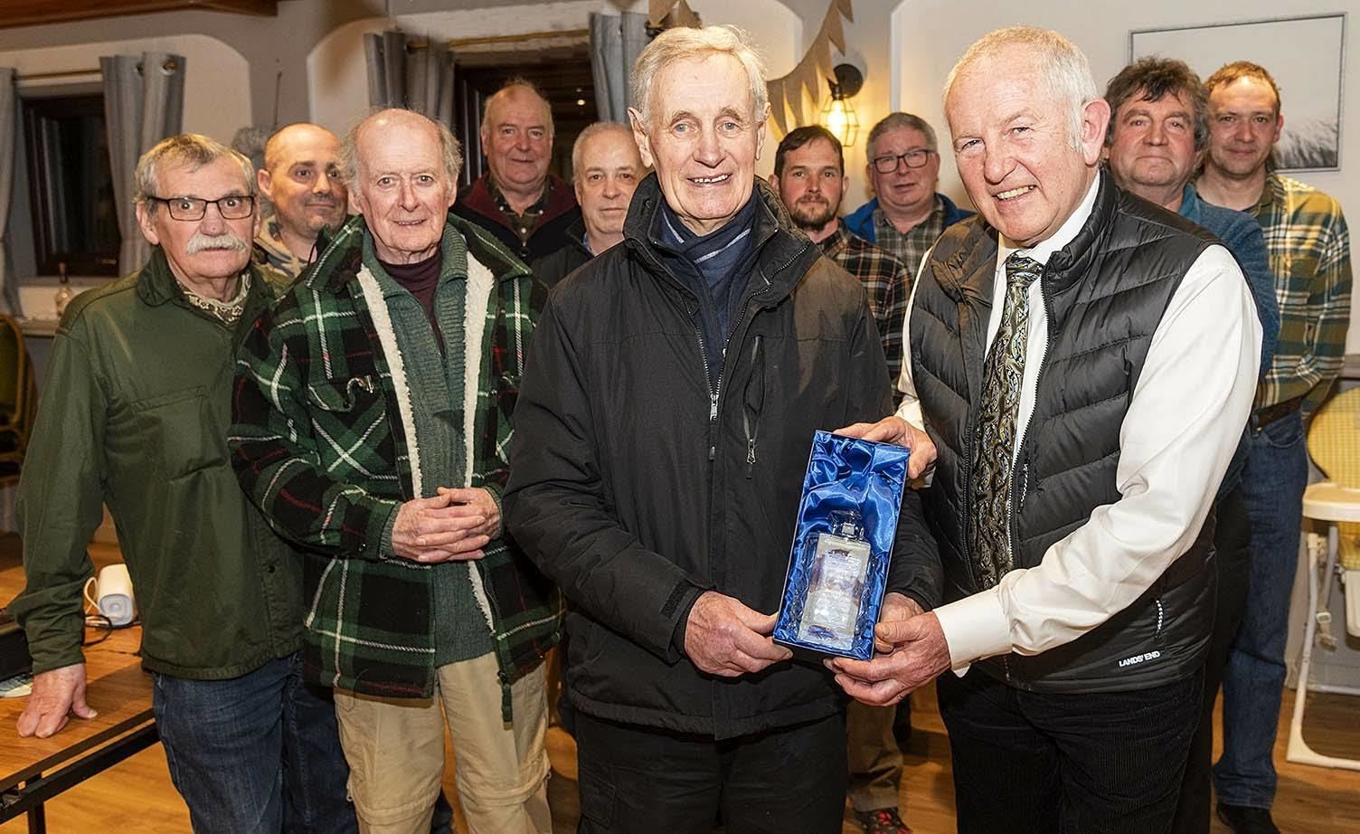 Stephen Dowds Chairman of Loch Achonachie Angling Club presents a decanter and Bottle of Whisky to Hugh Cushnie. Pic: Phil Downie.