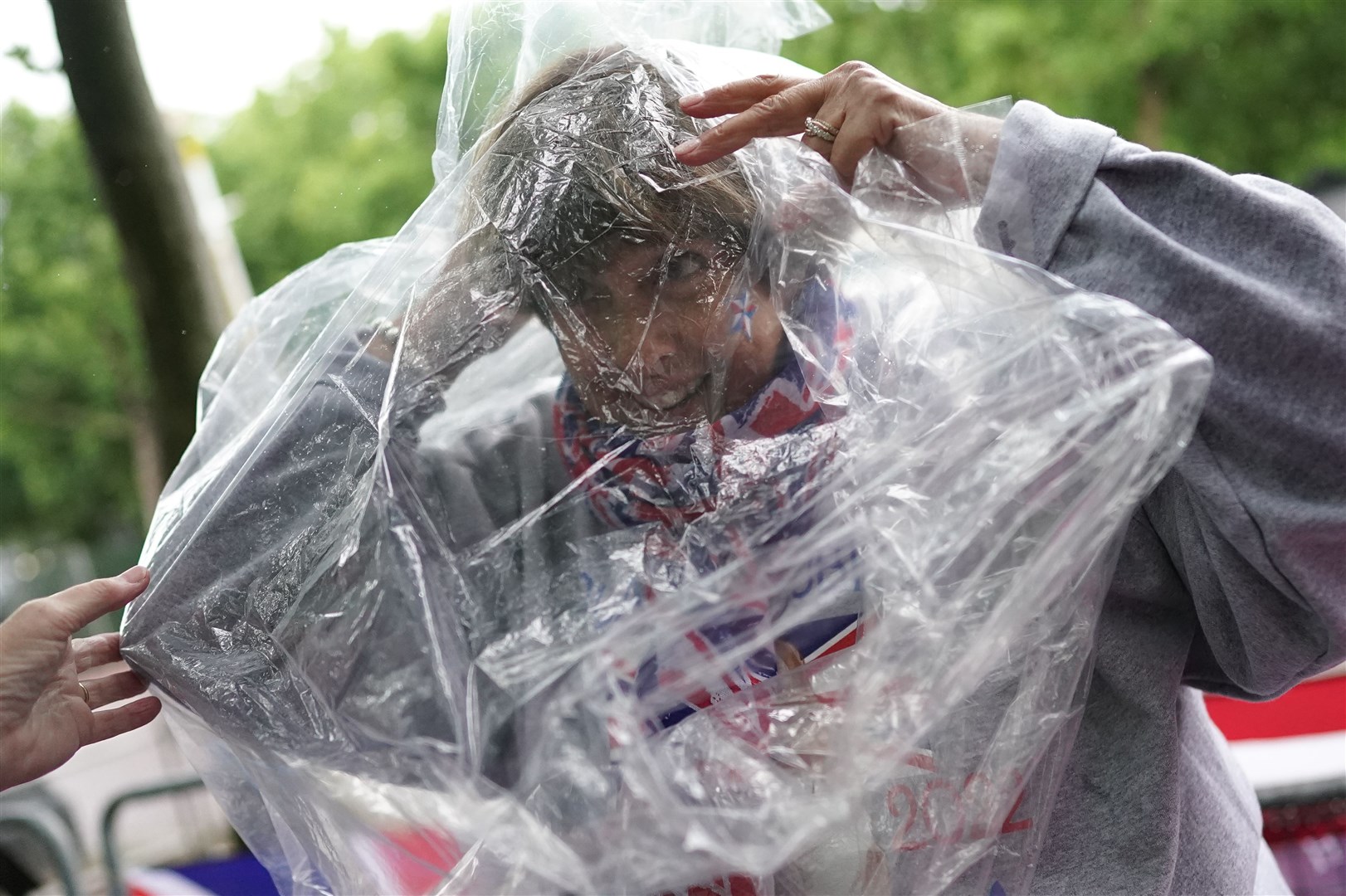 Royal superfan Donna Werner, from the US, puts on a rain cover on The Mall, near Buckingham Palace, on Tuesday (Aaron Chown/PA)