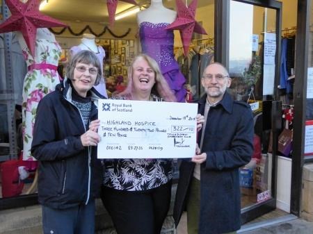 Heather McAllister and Dave Street of Tain and District Gardeners Club hand over a cheque from the Christmas Tree Festival to the Tain Highland Hospice Shop supervisor Susan Gibson.