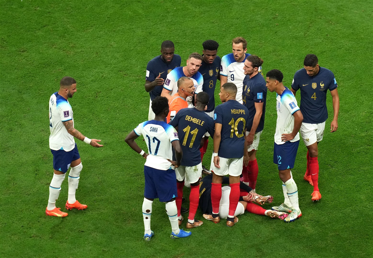 Players surround the referee during the first half (Peter Byrne/PA)