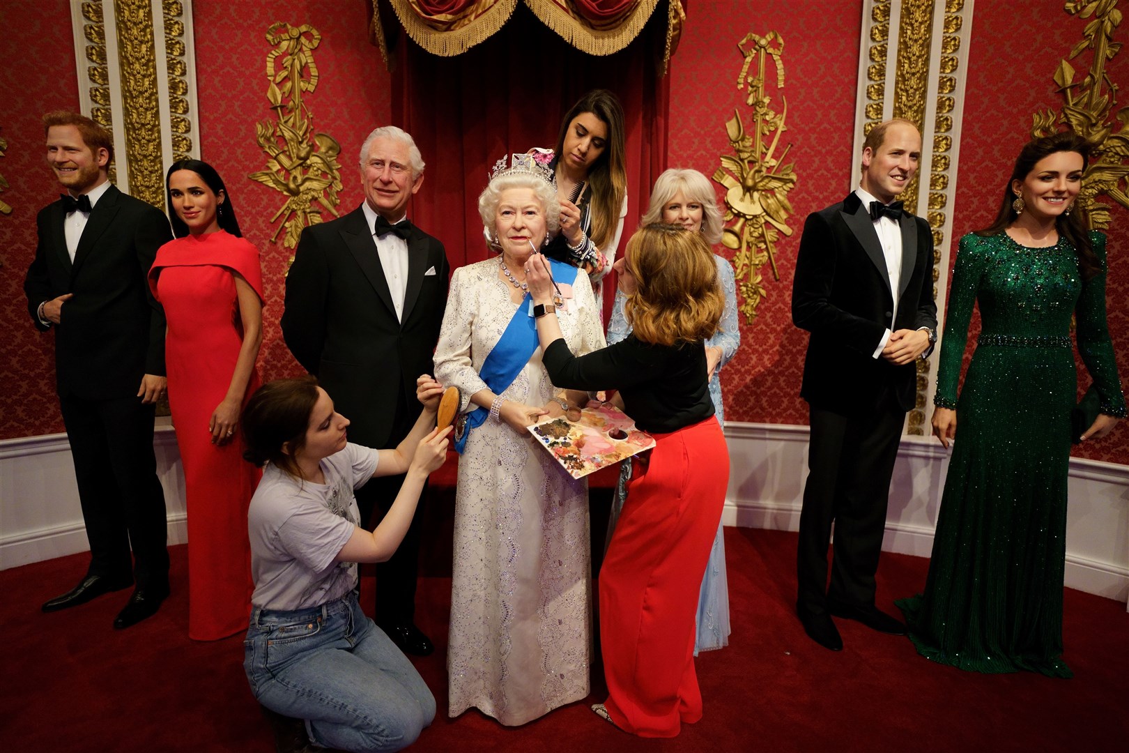Studio artists Luisa Compobassi (left), Caryn Mitanni (back) and Jo Kinsey (right) make their final touches to the wax figure of Queen Elizabeth II at Madame Tussauds London ahead the Platinum Jubilee celebrations. (PA)