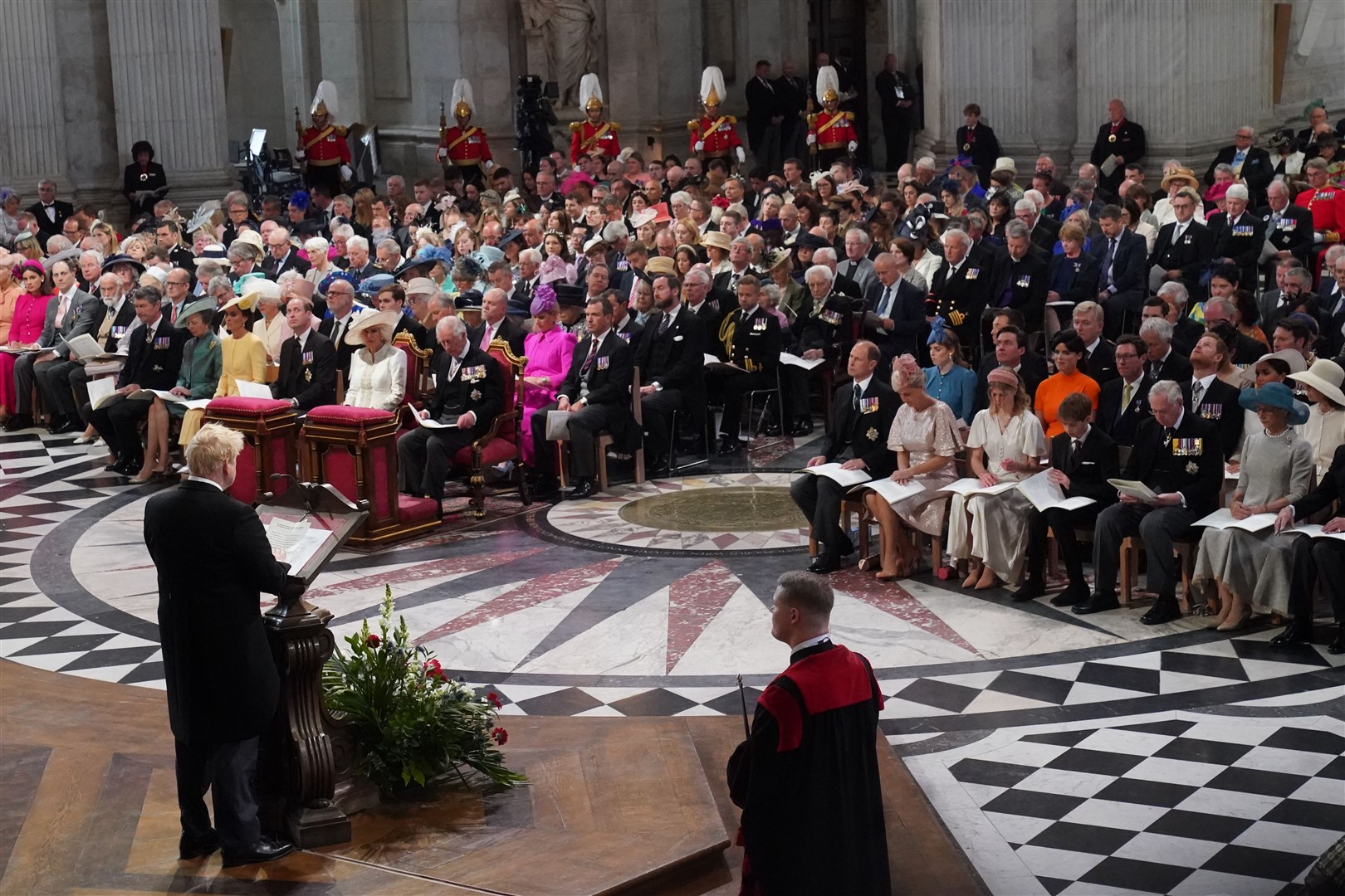 The royals – with Harry and Meghan far right – and congregation listen as Prime Minister Boris Johnson gives a reading (Aaron Chown/PA)