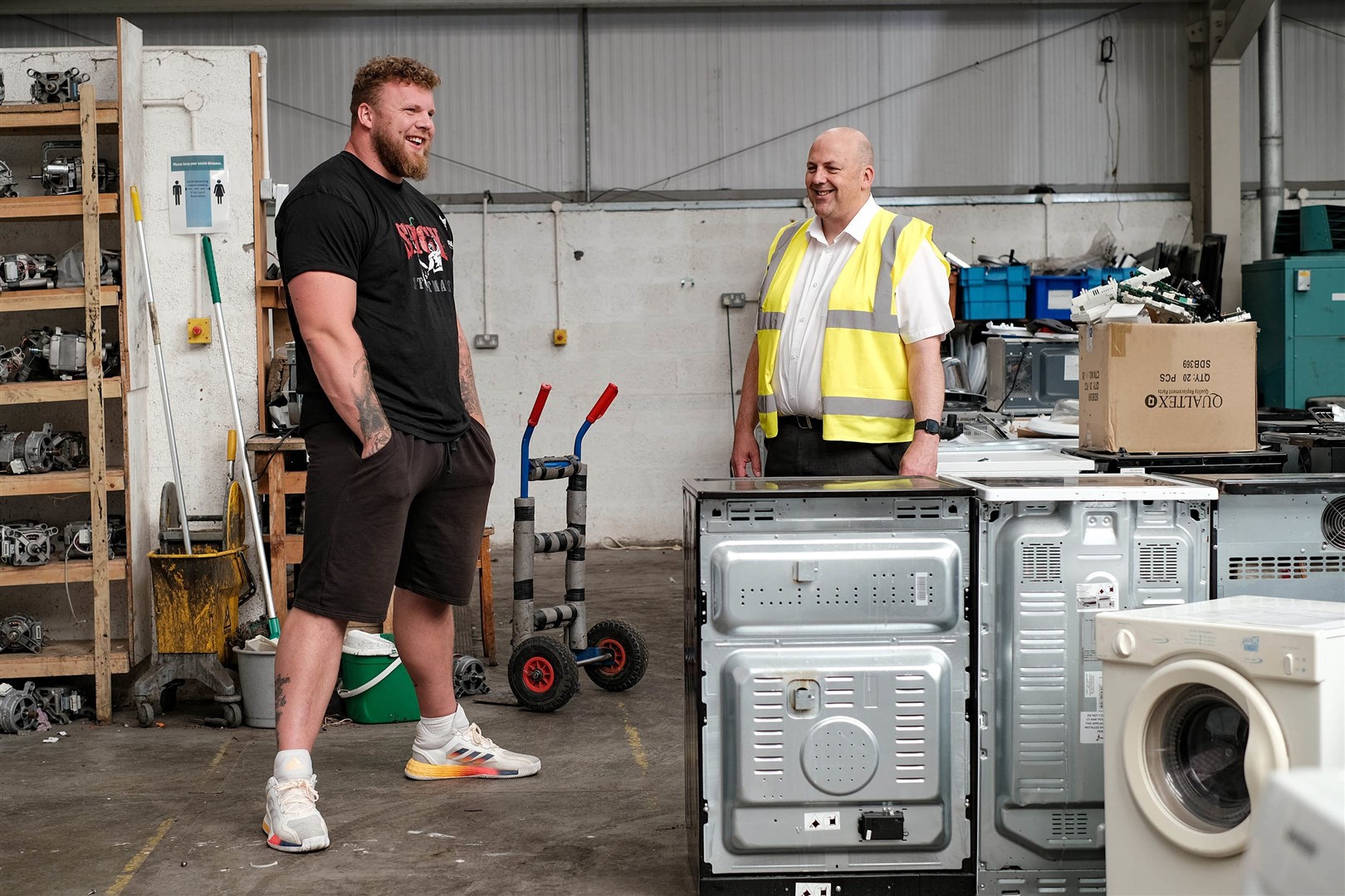 ILM Highland’s Martin MacLeod (right) explains the process of electrical appliance refurbishment to World’s Strongest Man Tom Stoltman.