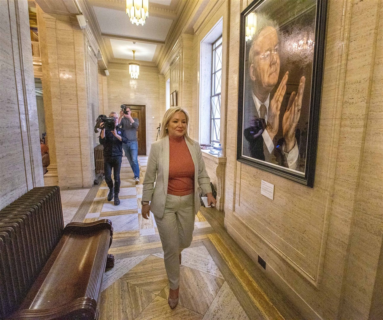Sinn Fein vice president Michelle O’Neill walks passed a portrait of former Deputy First Minister Martin McGuinness hanging in the Great Hall of Parliament Buildings at Stormont (Liam McBurney/PA)