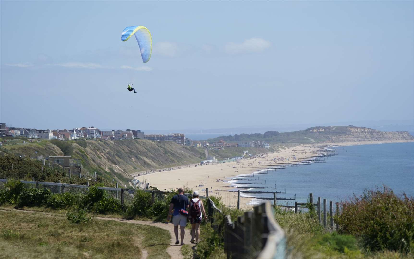 Further along the coast at Boscombe beach, a paraglider takes to the skies above the cliffs (Andrew Matthews/PA)