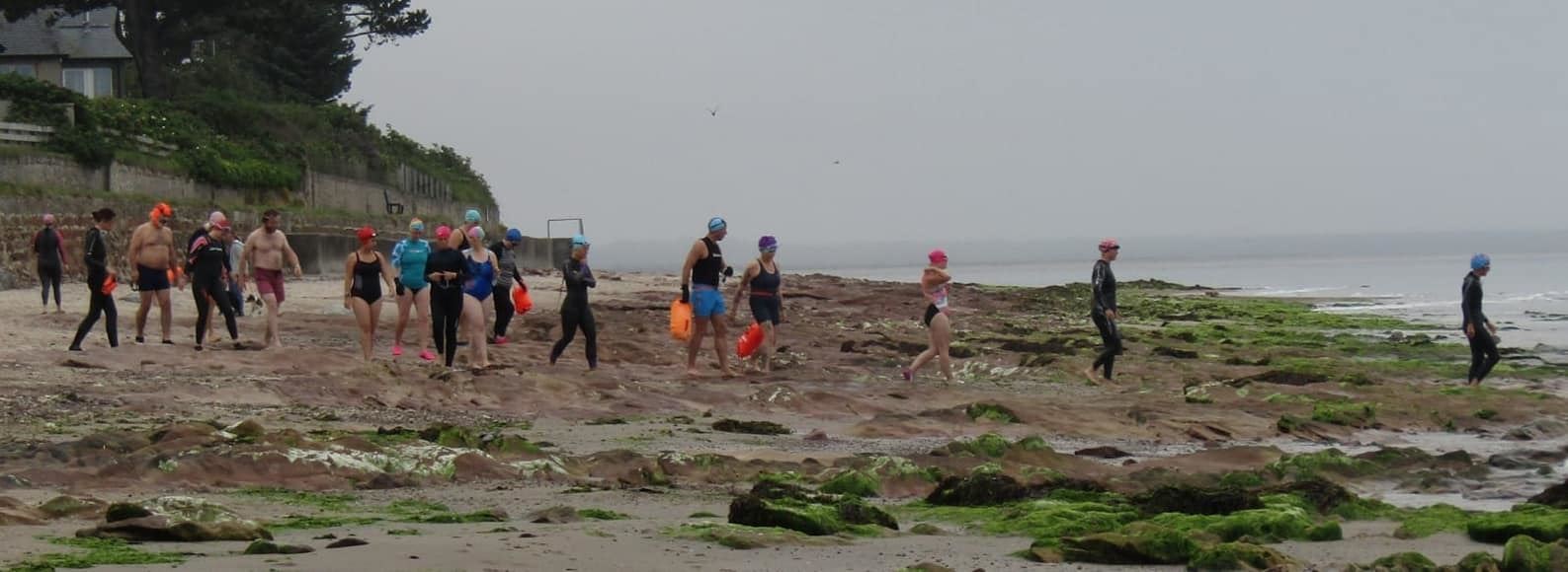 Swimmers head towards the beach.