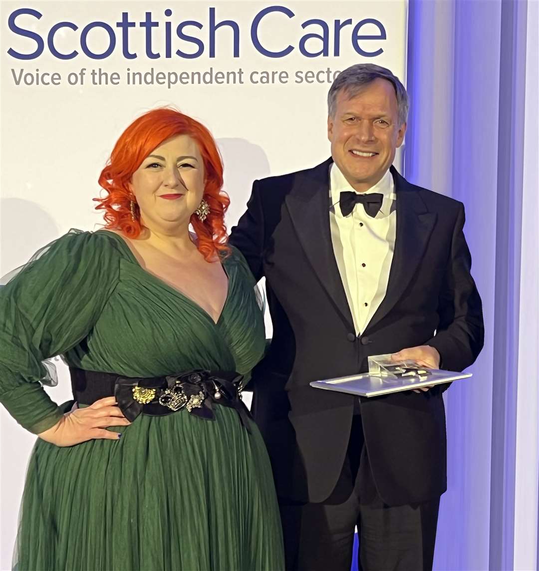 Ron Taylor receives the award from singer Michelle McManus.