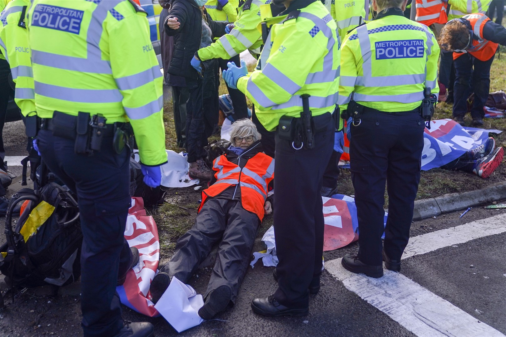 Police officers detain a protester from Insulate Britain occupying a roundabout leading from the M25 motorway to Heathrow Airport in London, earlier this week (Steve Parsons/PA)